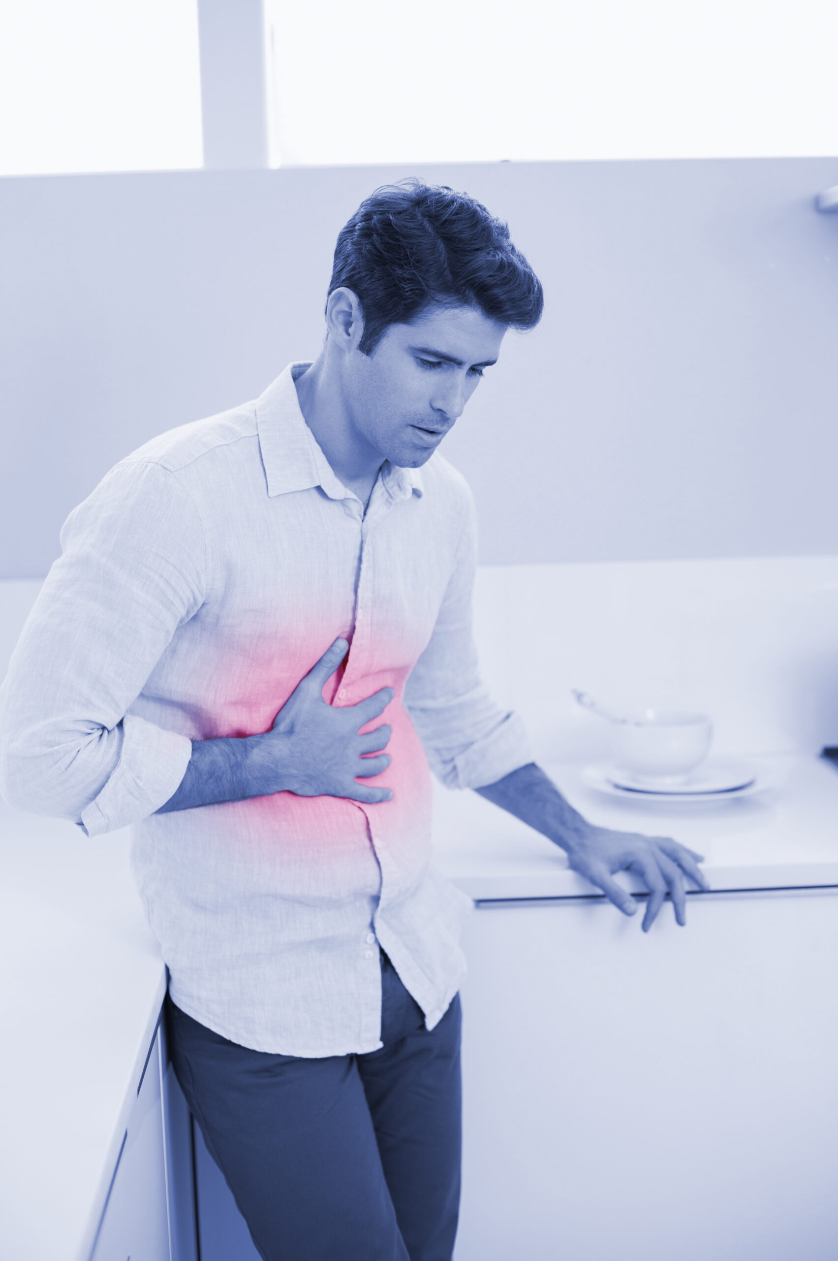 Hombre con dolor de estómago colocando la mano en el abdomen, mostrando molestias digestivas